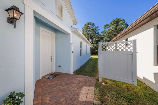 a view of a hallway with wooden floor and a bathroom