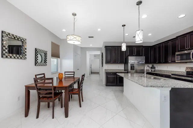 a kitchen with kitchen island granite countertop a stove sink and microwave