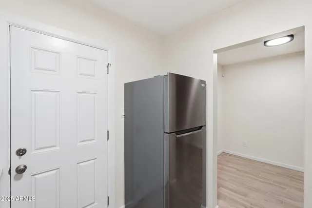 a view of a refrigerator in kitchen and white cabinets