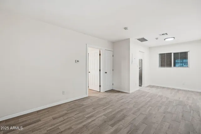 a view of an empty room with wooden floor
