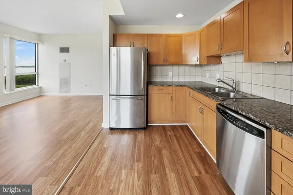 a kitchen with a sink a refrigerator freezer a stove top oven a counter space and cabinets