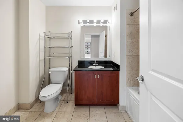 a spacious bathroom with a toilet a sink and a mirror