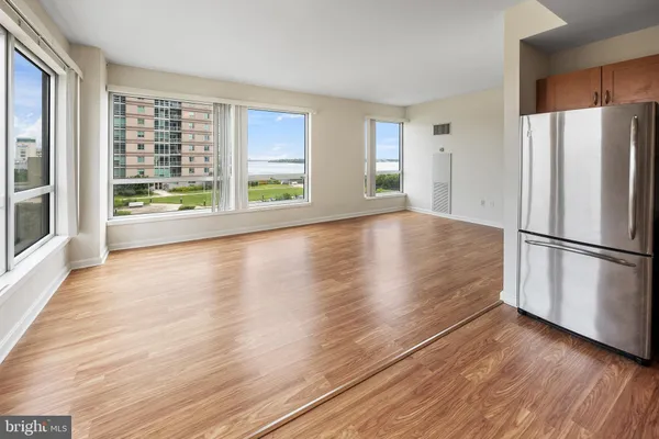 a view of a kitchen with wooden floor and stainless steel appliances