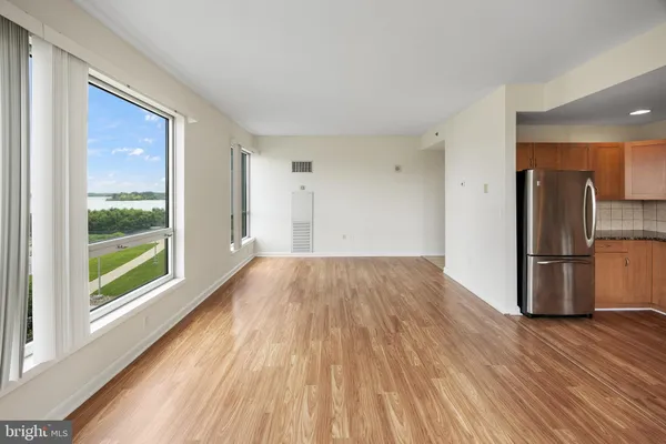 a view of a kitchen with wooden floor and a refrigerator