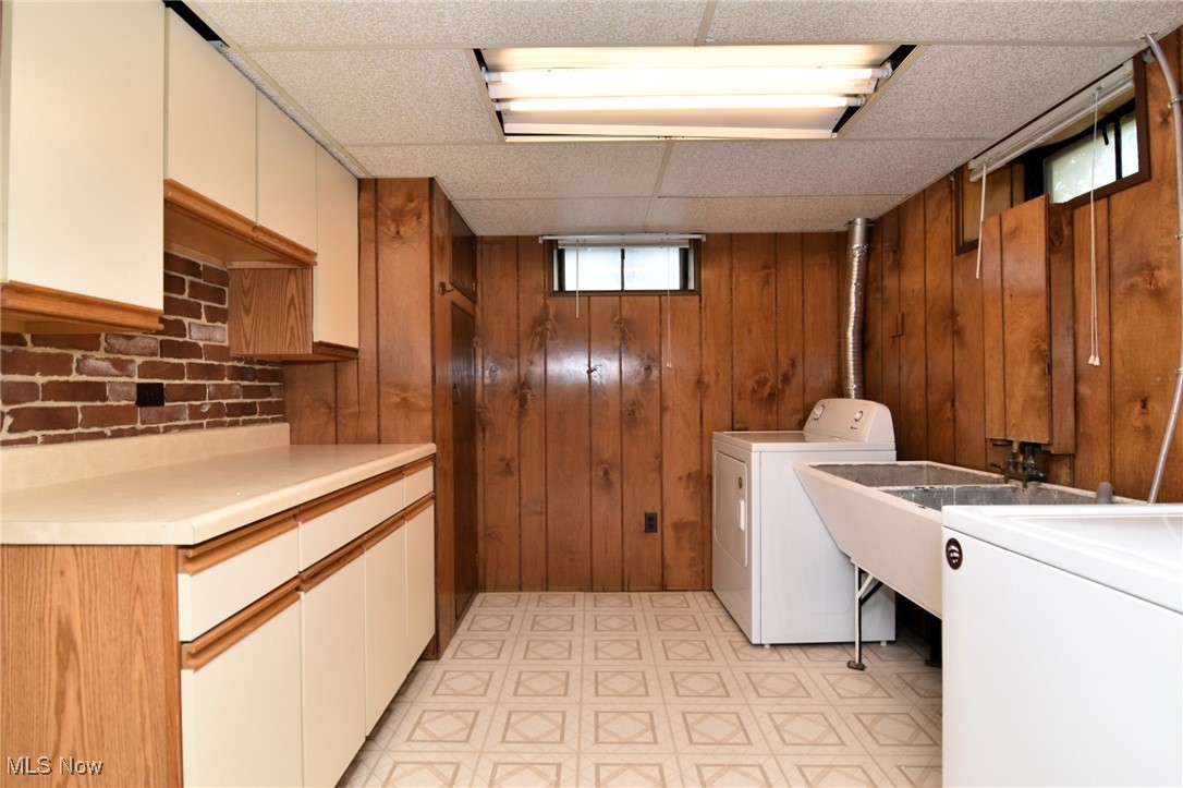 317 Nobottom Road Berea, OH 44017 - Photo 37 of 49 Laundry room featuring cabinets, wood walls, separate washer and dryer, and light tile patterned floors