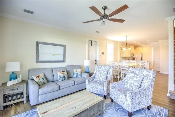 a living room with furniture and a view of kitchen