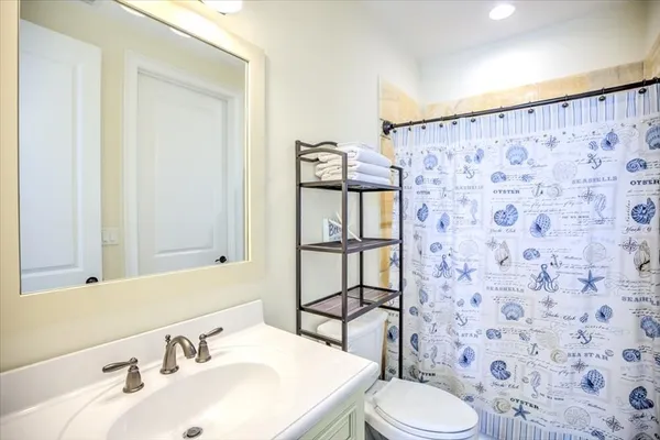 a bathroom with a sink a toilet and shower curtain