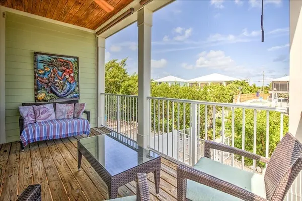 a view of a balcony with furniture and floor to ceiling window