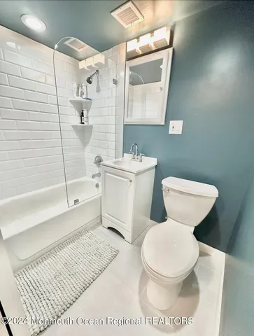 a white toilet sitting next to a bathroom sink and a shower