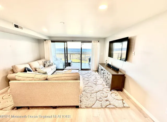 a living room with furniture and large windows