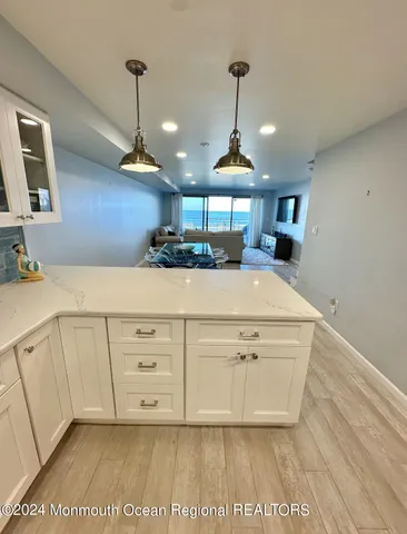 a view of a kitchen with kitchen island a sink wooden floor and counter space
