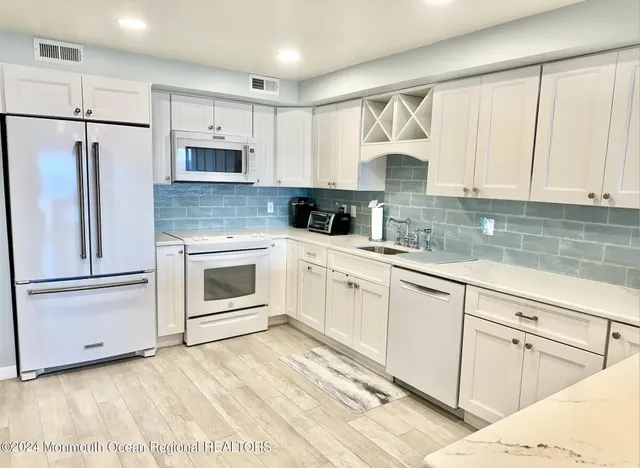 a kitchen with cabinets stainless steel appliances and sink