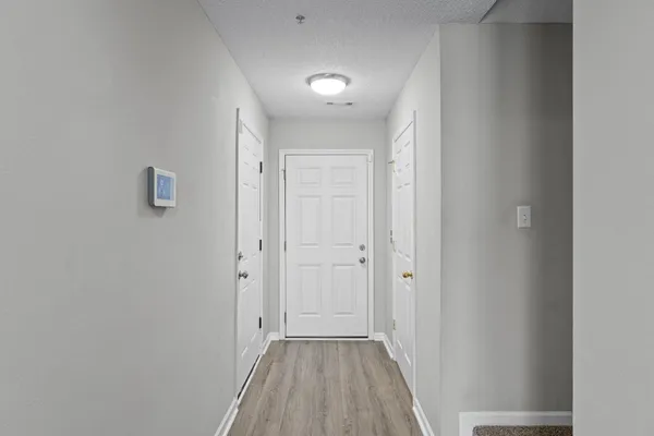 a view of a hallway with wooden floor