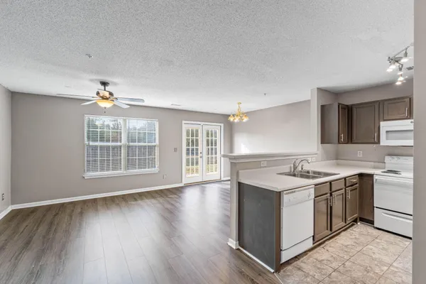 a view of a kitchen counter space a sink wooden floor and a window
