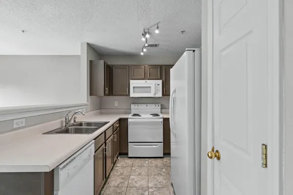 a kitchen with a sink dishwasher a stove and a refrigerator