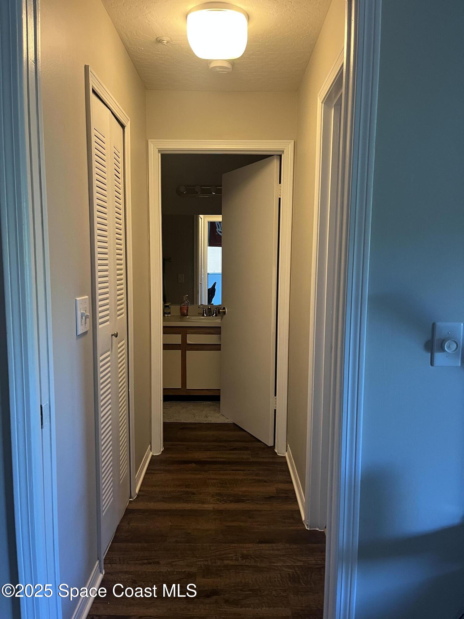 7667 North Wickham Road, Unit 1118 Melbourne, FL 32940 - Photo 13 of 17 a view of a hallway with wooden floor and a bathroom