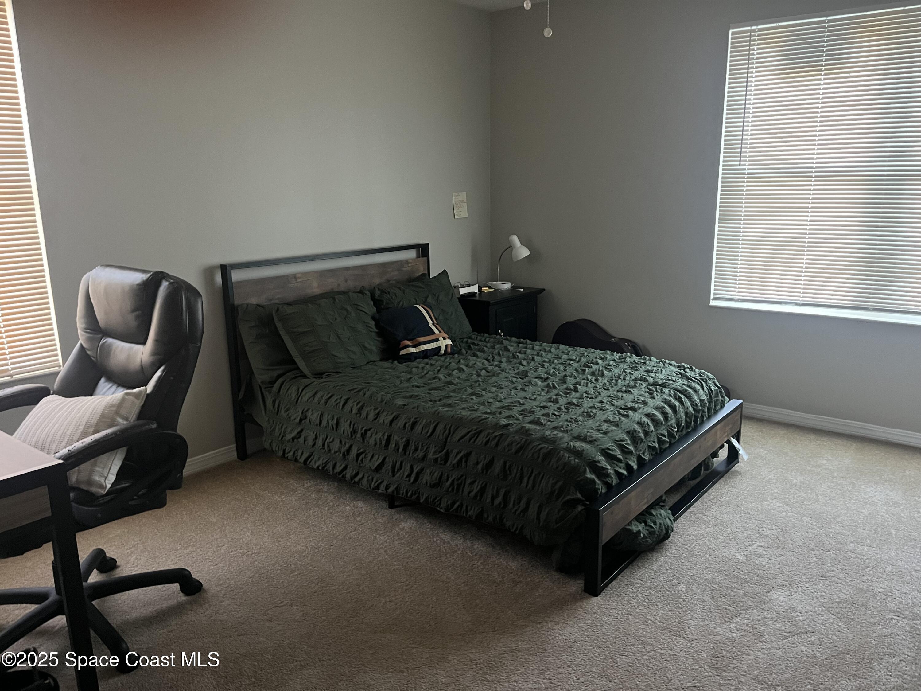 7667 North Wickham Road, Unit 1118 Melbourne, FL 32940 - Photo 14 of 17 a bedroom with a bed chair and window