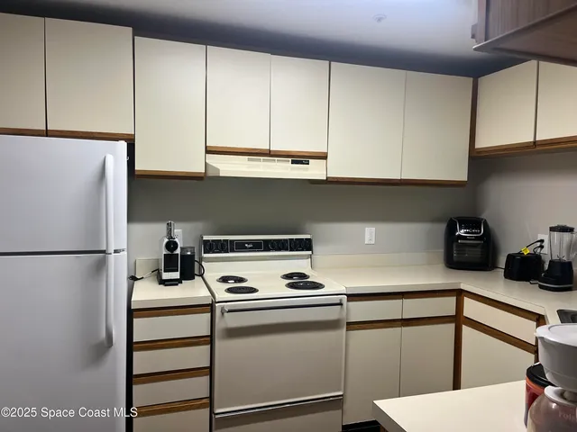a kitchen with a refrigerator and cabinets