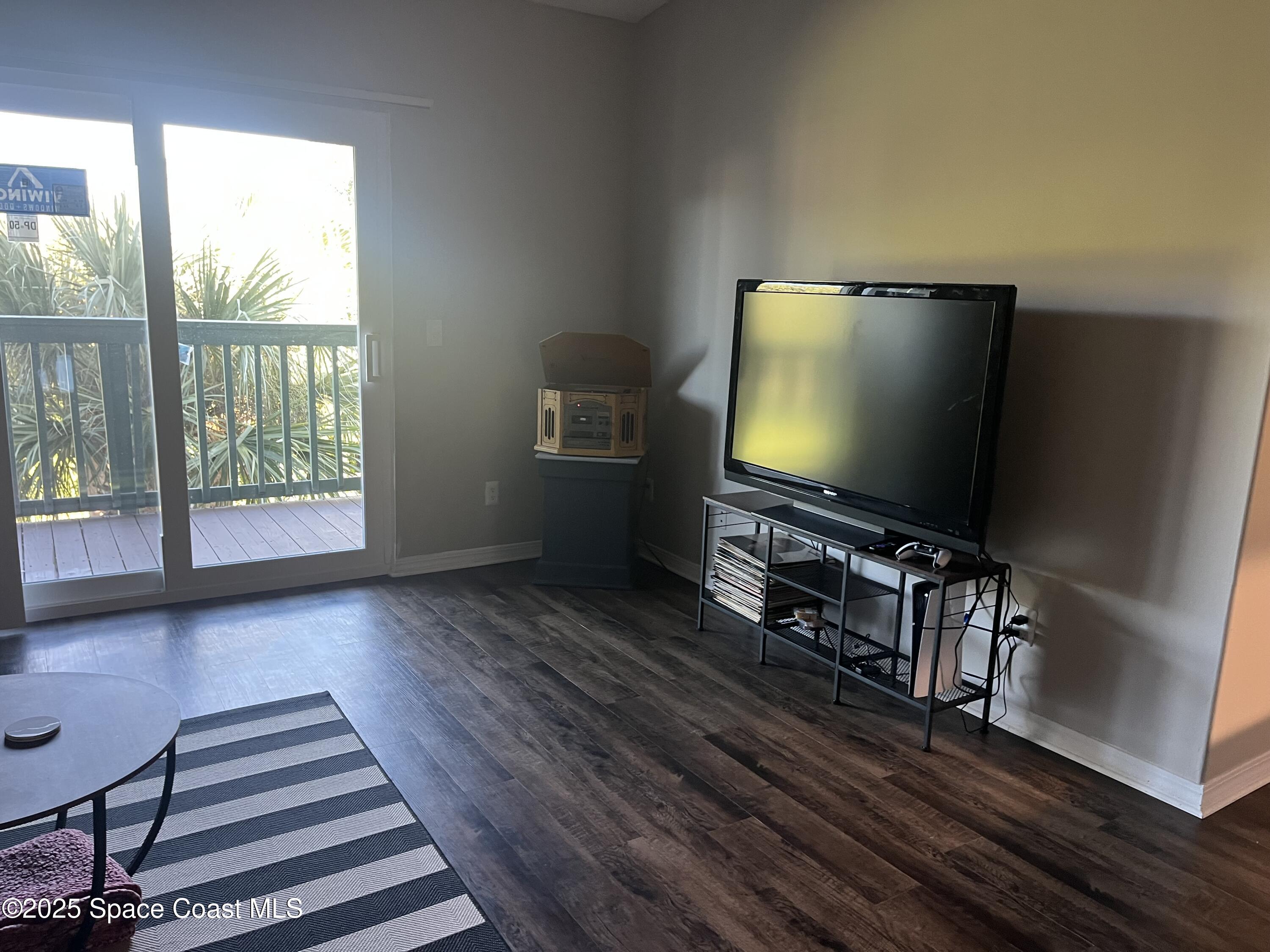 7667 North Wickham Road, Unit 1118 Melbourne, FL 32940 - Photo 7 of 17 a living room with furniture and a flat screen tv