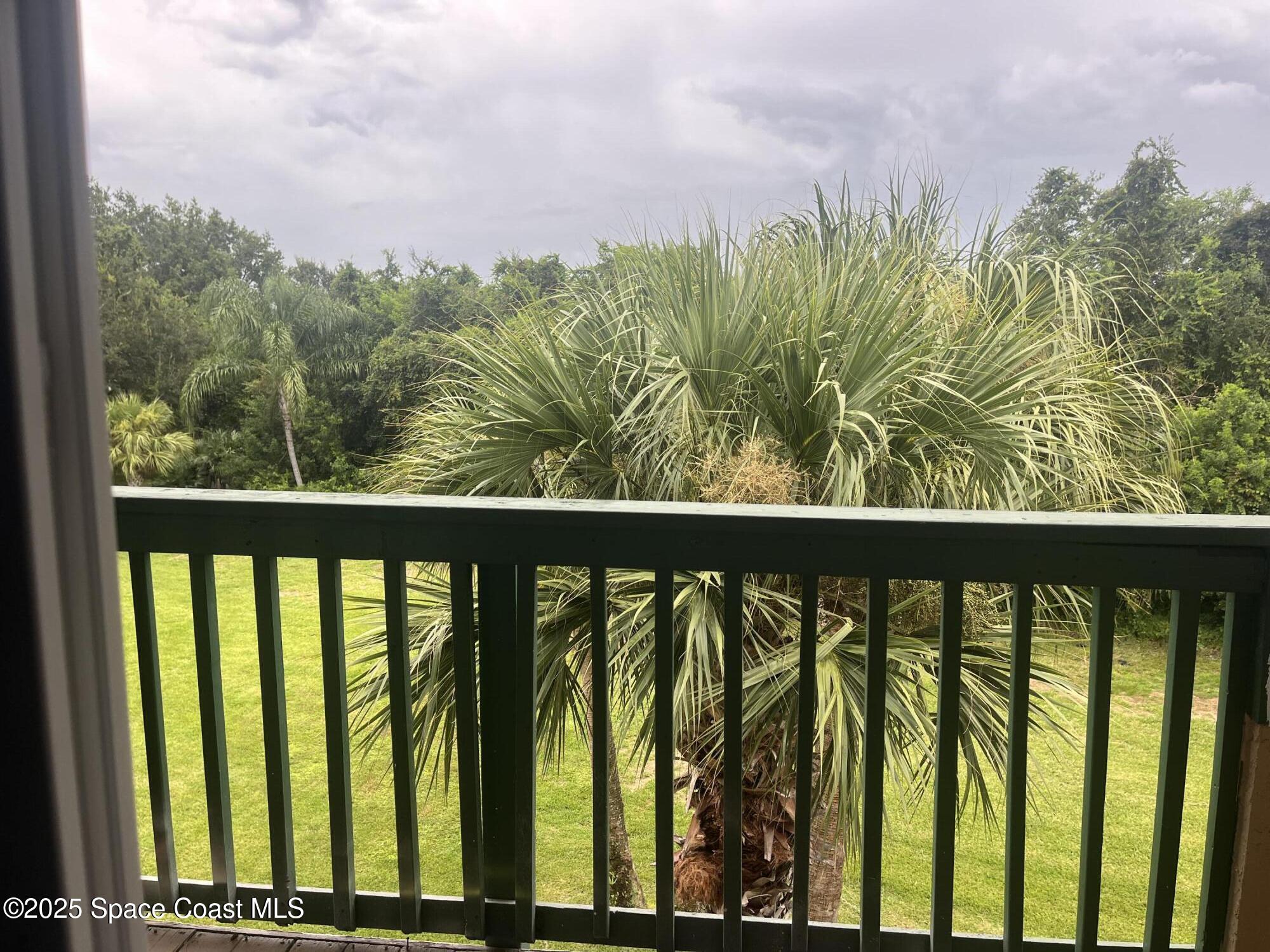7667 North Wickham Road, Unit 1118 Melbourne, FL 32940 - Photo 8 of 17 a view of a balcony next to a yard