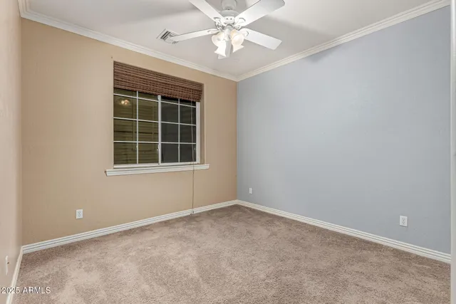 an empty room with a window and ceiling fan