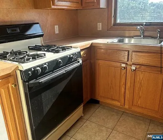 a kitchen with granite countertop a sink stove and cabinets