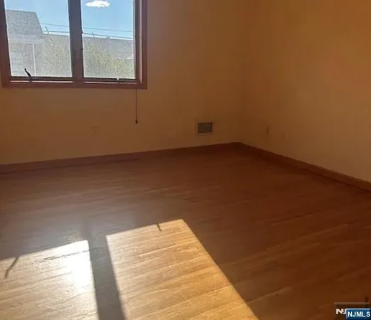 a view of a room with wooden floor and a window