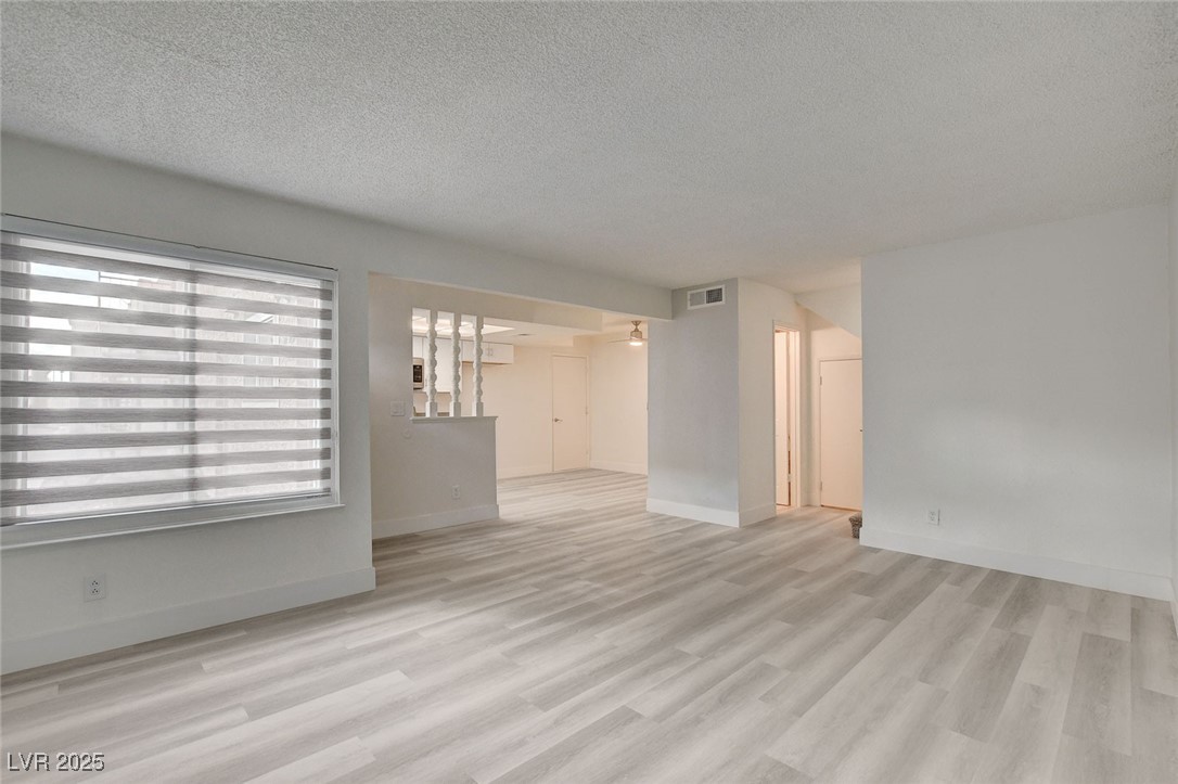 579 Roxella Lane, Unit B Las Vegas, NV 89110 - Photo 2 of 28 Unfurnished living room with a textured ceiling and light wood-style flooring