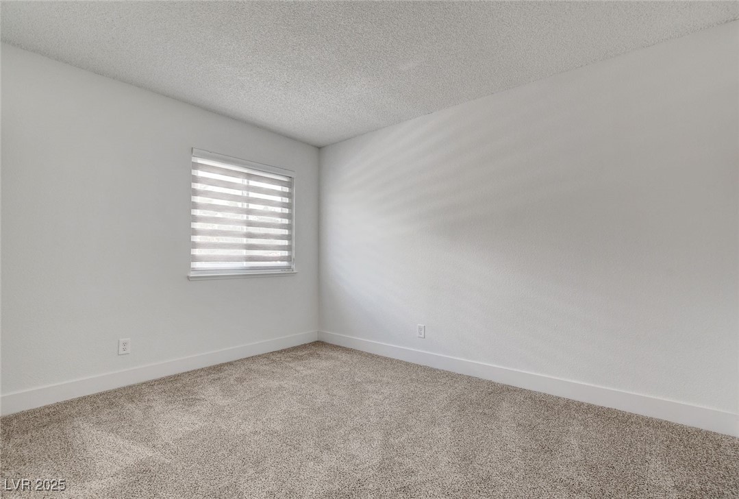 579 Roxella Lane, Unit B Las Vegas, NV 89110 - Photo 21 of 28 Carpeted spare room with baseboards and a textured ceiling