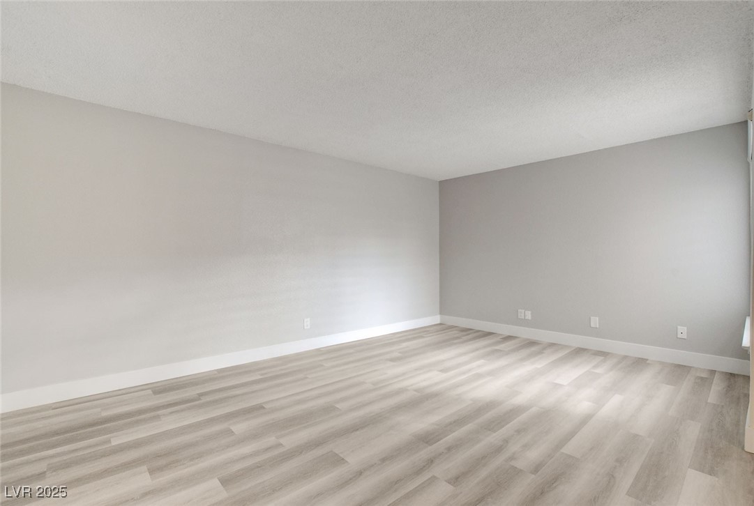 579 Roxella Lane, Unit B Las Vegas, NV 89110 - Photo 3 of 28 Spare room featuring light wood finished floors and a textured ceiling