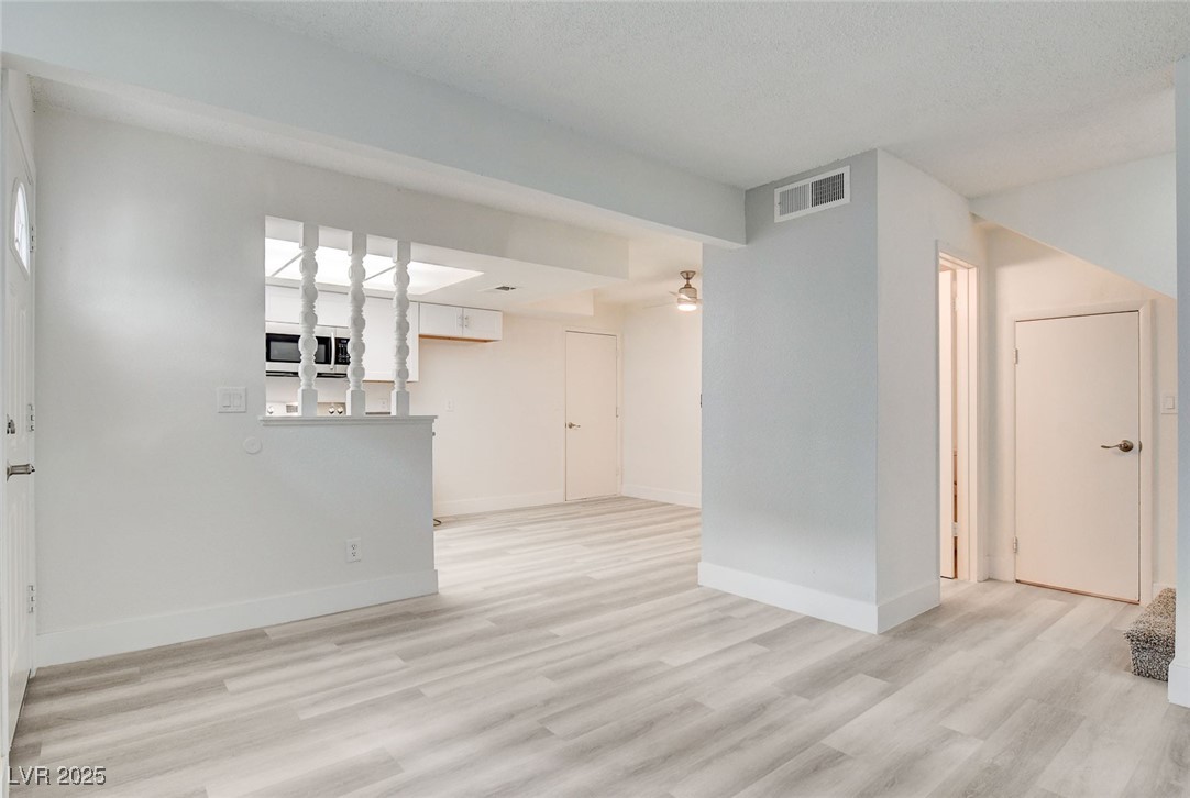 579 Roxella Lane, Unit B Las Vegas, NV 89110 - Photo 8 of 28 Unfurnished living room featuring light wood-type flooring and ceiling fan