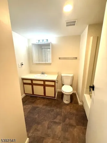 a bathroom with a toilet a sink and mirror