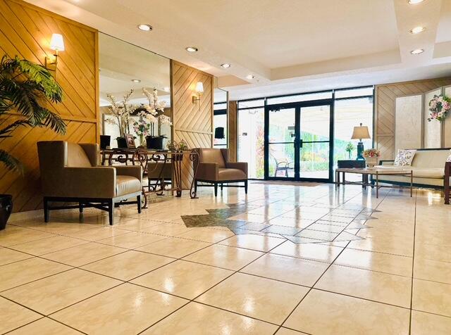 3051 North Course Drive, Unit 209 Pompano Beach, FL 33069 - Photo 13 of 17 a living room with couches a dining table and chairs with a large window