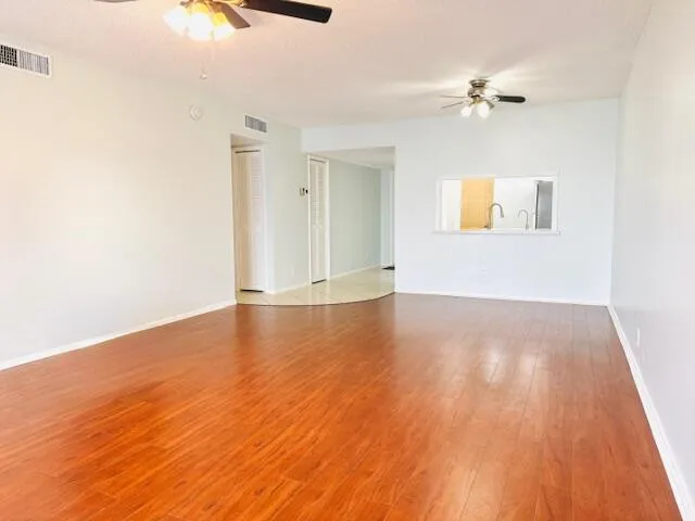 an empty room with a window and a fan
