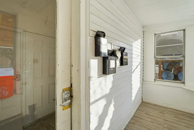 a view of a hallway with wooden floor and a living room