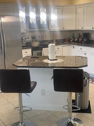 a living room with stainless steel appliances kitchen island granite countertop furniture and a kitchen view