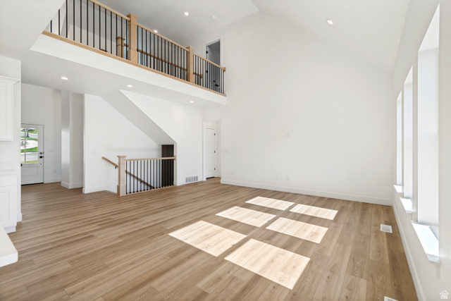 1351 Maple Circle Santaquin, UT 84655 - Photo 11 of 42 Spacious living area featuring high vaulted ceilings, light wood-finish flooring, and multiple vertical windows