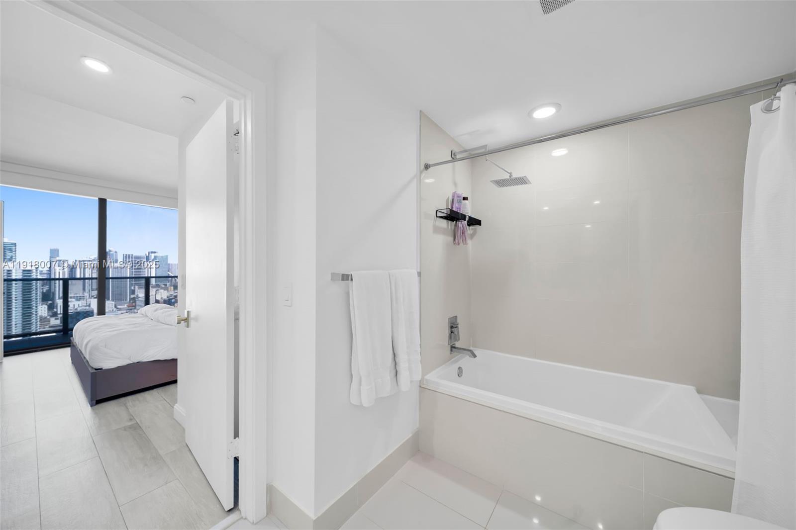 45 Southwest 9th Street, Unit 3909 Miami, FL 33130 - Photo 15 of 23 a bathroom with a tub shower hardwood