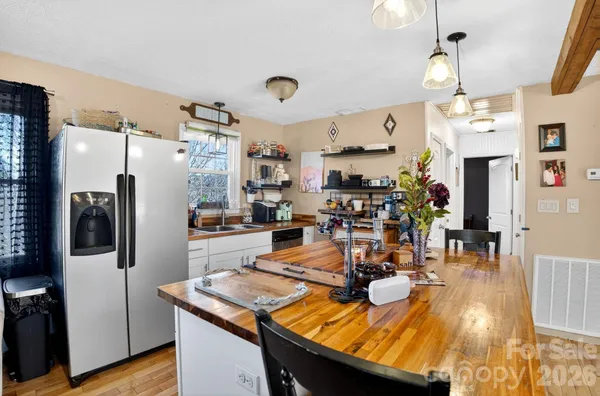 a view of a dining room and livingroom with furniture wooden floor a chandelier