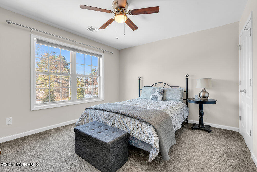 17 Green Tree Circle Hazlet, NJ 07730 - Photo 19 of 29 a spacious bedroom with a bed a chandelier and a window
