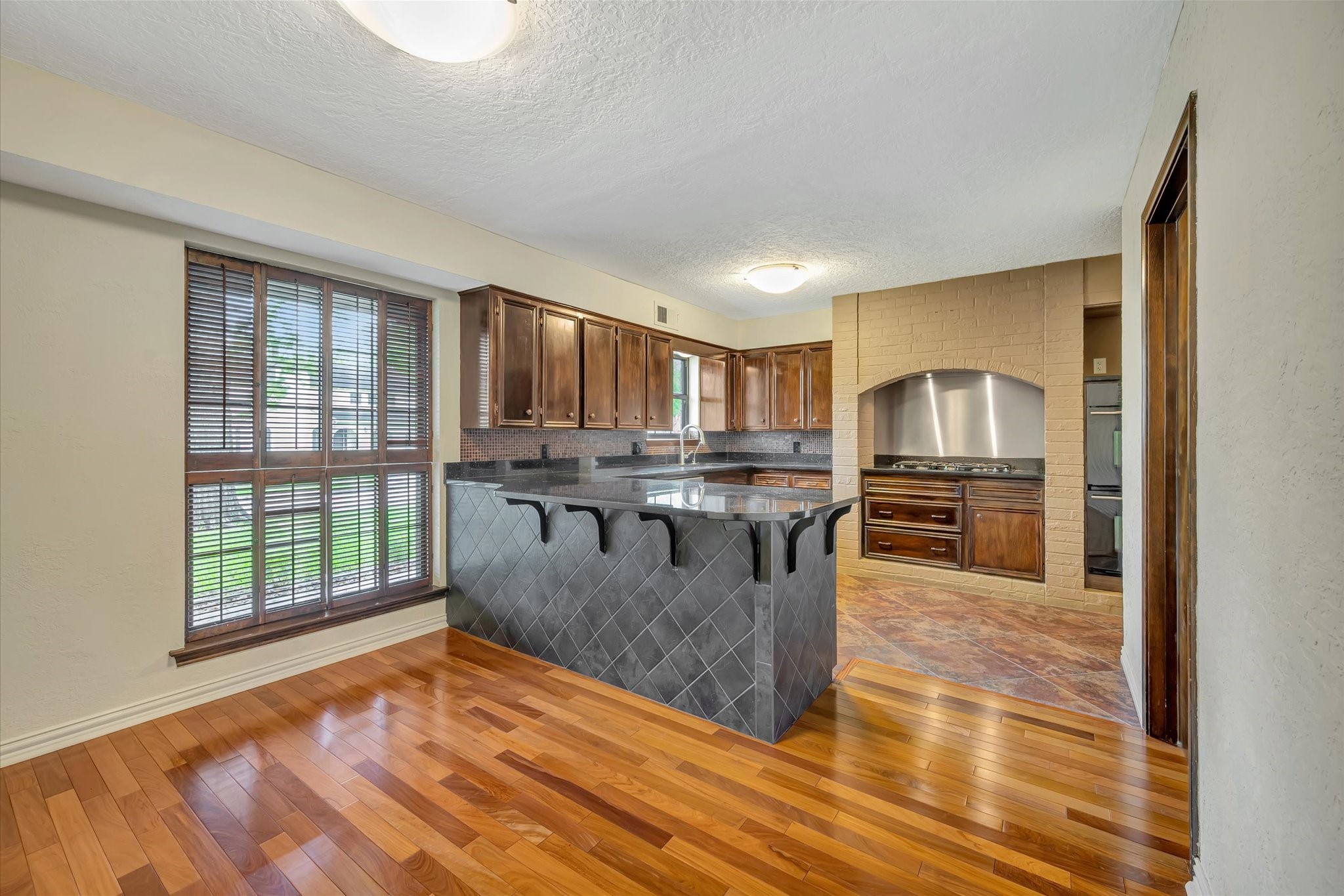 822 Devonport Lane Seabrook, TX 77586 - Photo 23 of 50 a kitchen with stainless steel appliances granite countertop a stove top oven a sink dishwasher a dining table and chairs with wooden floor