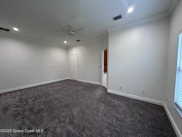 an empty room with a ceiling fan and window