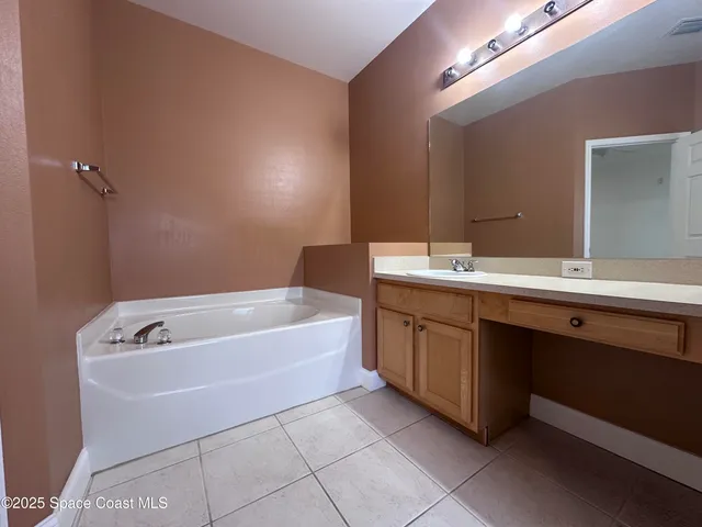 a bathroom with a tub sink and mirror
