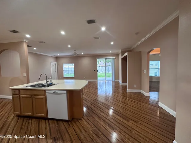 a kitchen with stainless steel appliances granite countertop a sink a stove and a wooden floors