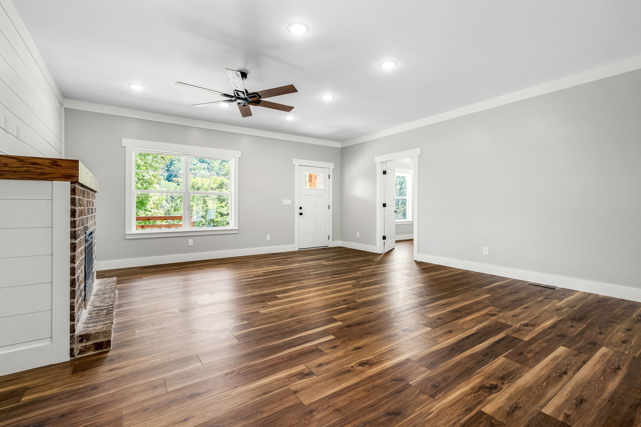 2305 Hurricane Creek Road Lynchburg, TN 37352 - Photo 23 of 54 an empty room with wooden floor chandelier fan and windows