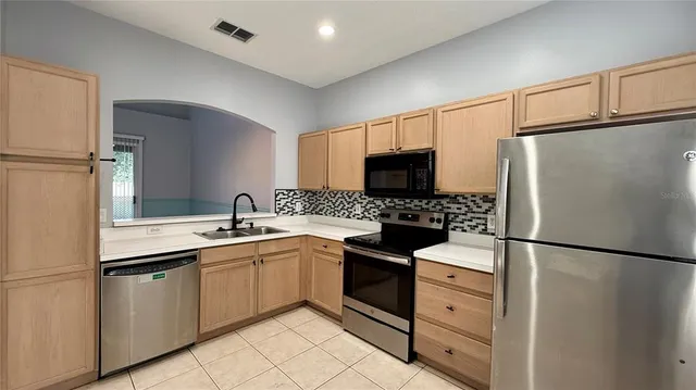 a kitchen with white cabinets stainless steel appliances and a sink
