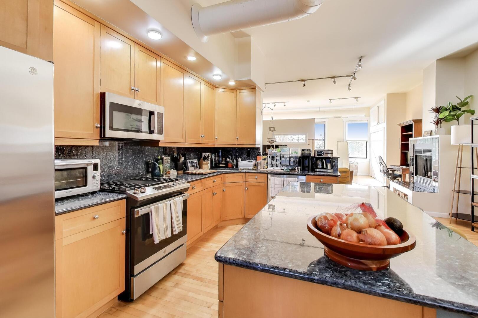 400 North Racine Avenue, Unit 204 Chicago, IL 60642 - Photo 9 of 22 a large kitchen with stainless steel appliances granite countertop a sink a stove and a wooden cabinets