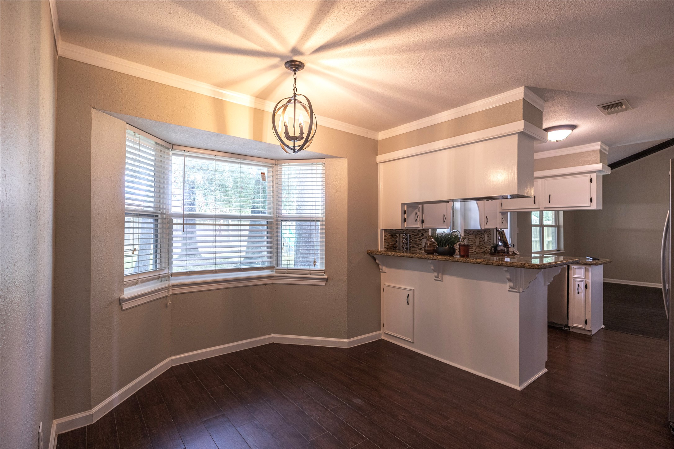 14419 Wadebridge Way Houston, TX 77015 - Photo 7 of 20 The photo showcases a cozy dining area with a bay window and modern pendant light. It features a breakfast are or can also be used for a desk or homework area.