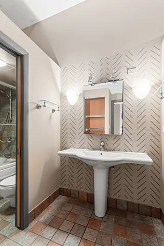 a bathroom with a sink a toilet and mirror