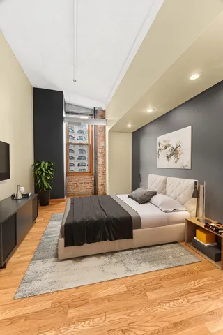 a spacious bedroom with a large bed and a chandelier